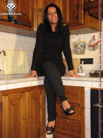 European Brunette Frees Her Feet from High Heels in the Kitchen