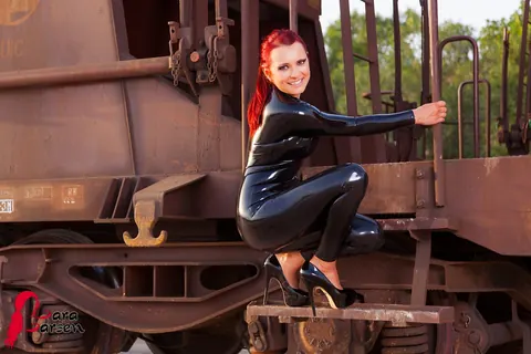 Lara Larsen: Redhead in a Latex Bodysuit and High Heels Poses on a Train Platform – photo 12 of 12