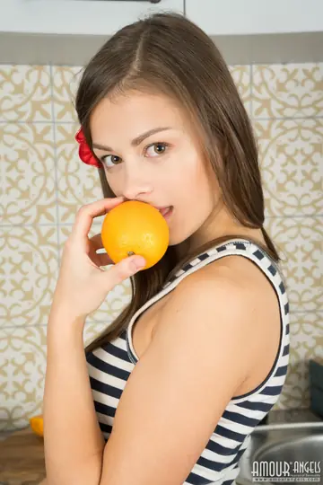 Woman Slices Orange Then Strips and Spreads in the Kitchen