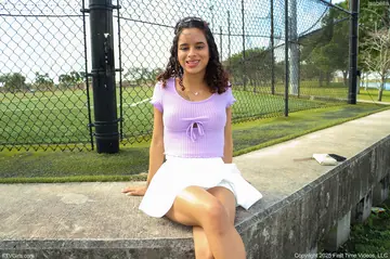 Latina in a Skirt and Sneakers Shows Her Enhanced Tits Outdoors