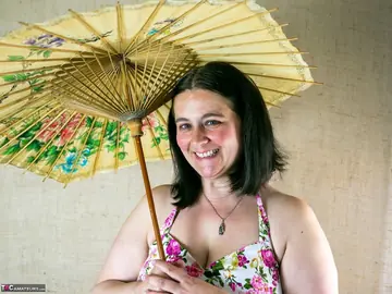 Mature Curvy Woman Strips Out of Her Skirt While Holding Umbrella