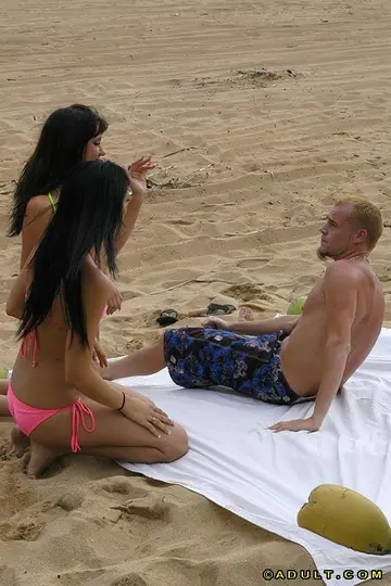 Brunette in a Bikini Joins a Threesome on the Beach