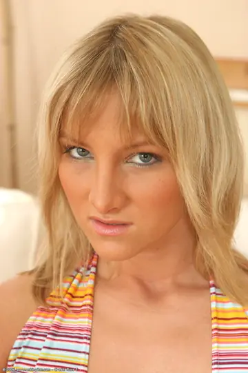 Blonde Undresses and Poses Nude Displaying Her Figure