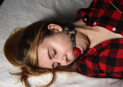 Woman Bound and Ball-Gagged in Shorts on the Bed – photo 6 of 16