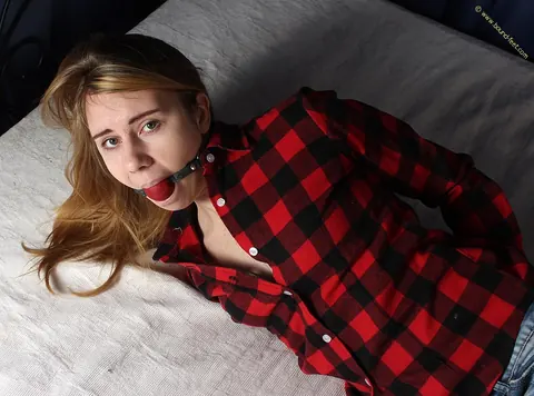 Woman Bound and Ball-Gagged in Shorts on the Bed – photo 9 of 16