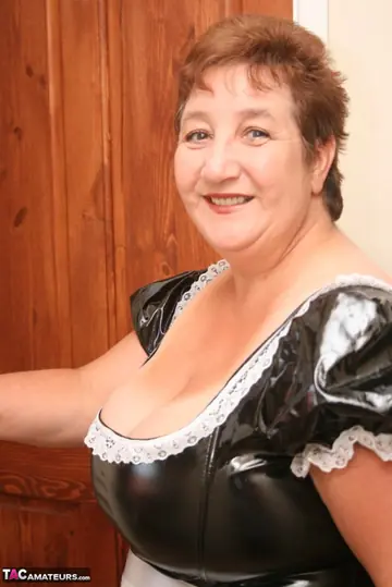 Mature Brunette Unbuttons Her Latex Maid Outfit to Show Her Big Tits