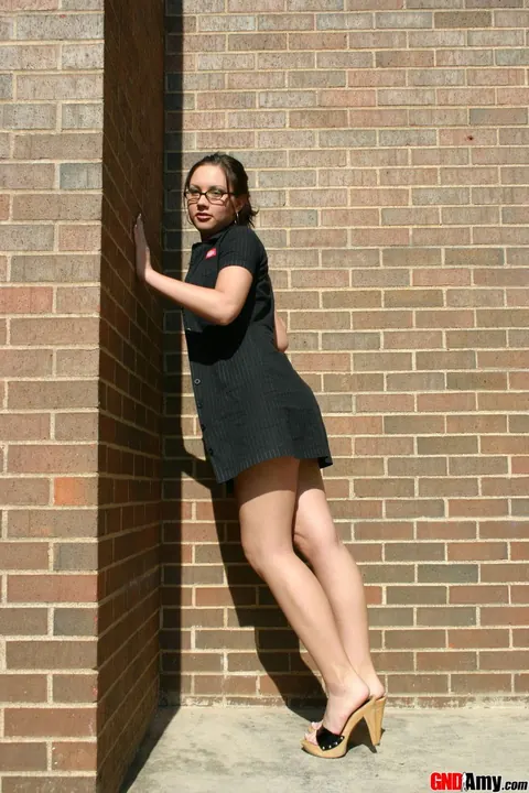 Thick Woman in Glasses Strips to Lingerie by Brick Wall – photo 3 of 12