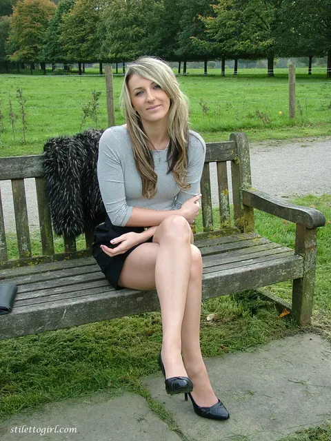 Tall Blonde Poses in a Skirt and Heels on a Country Bench – photo 9 of 16