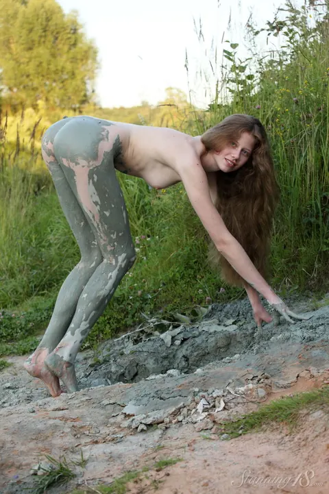 Tall European Woman Coats Body in Mud Outdoors – photo 6 of 16
