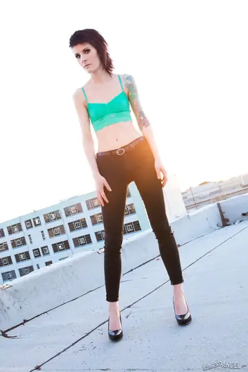 Skinny Tattooed Woman Exposes Her Tits in Jeans on a Rooftop
