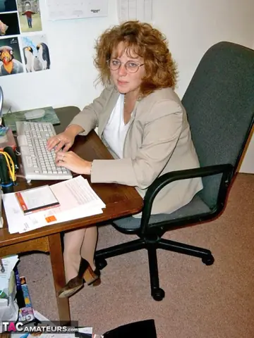 Curvy Claire – British Redhead MILF Poses in Lingerie and Boots at the Office