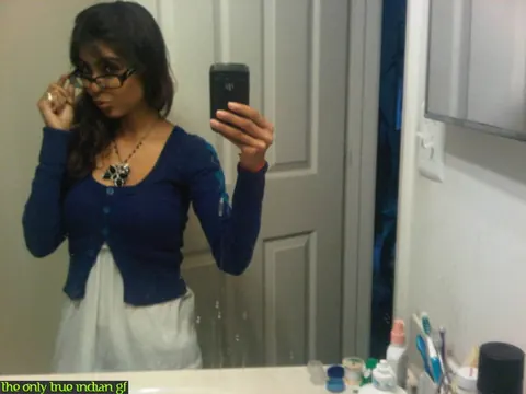 Indian Woman Poses in Boots and Glasses for Bathroom Mirror Selfies – photo 2 of 10