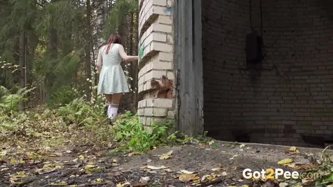 Redhead Crouches by a Building in a Skirt and Leather Boots – photo 15 of 15