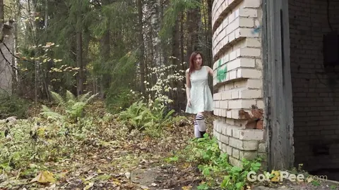Redhead Crouches by a Building in a Skirt and Leather Boots – photo 1 of 15