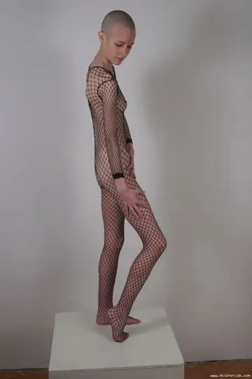Skinny Shaved-Head Model Shows Her Pussy in Fishnet Pantyhose