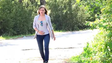 Woman in Jeans Squats and Spreads Outdoors