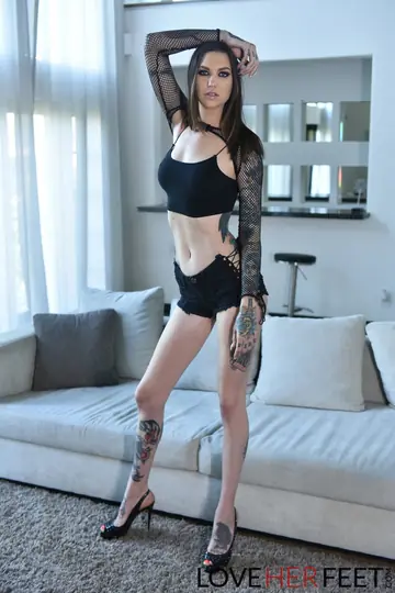 Tall Tattooed Brunette Gives a Footjob in High Heels