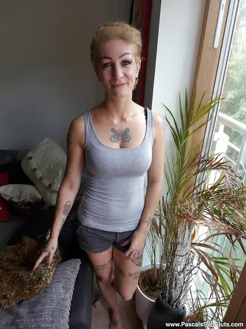 Busty Tattooed Woman Frees Ass from Shorts and Fingers Her Pussy
