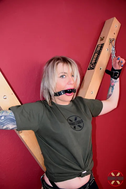 Tattooed Blonde Bound to Cross with Ball Gag in Shorts – photo 14 of 16
