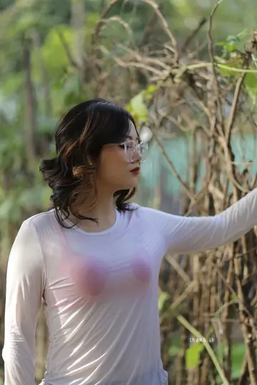 Curly Asian Woman Poses Outdoors in Glasses