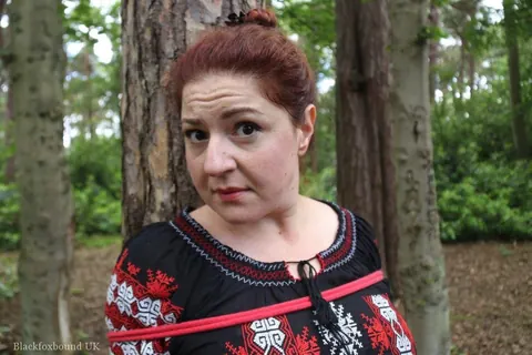 Thick Redhead in a Skirt and Leather Bound to a Tree – photo 7 of 16