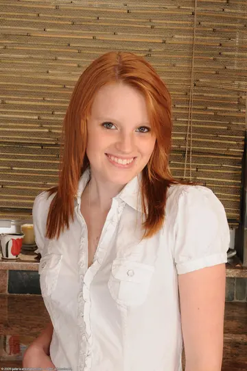 Skinny Redhead Undresses and Poses Nude Showing Her Tattoos