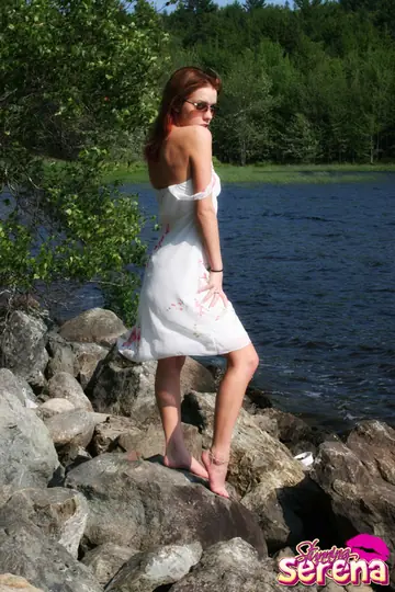 Stunning Serena – PAWG Redhead in a Skirt and Glasses Poses on Waterside Rocks