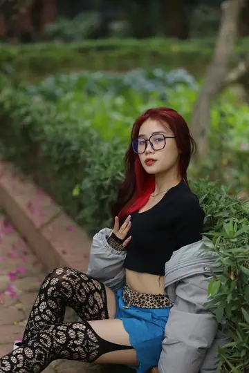Asian Redhead in Glasses Poses in Shorts and Stockings in the Garden