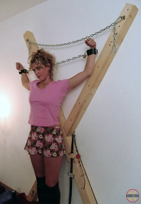 Blonde in Boots and Skirt Restrained on a Cross – photo 14 of 16