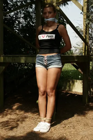 Blonde Tied to a Wooden Frame in the Forest