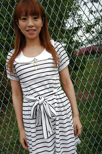 Asian Woman Lifts Hem of Short Dress on Outdoor Path