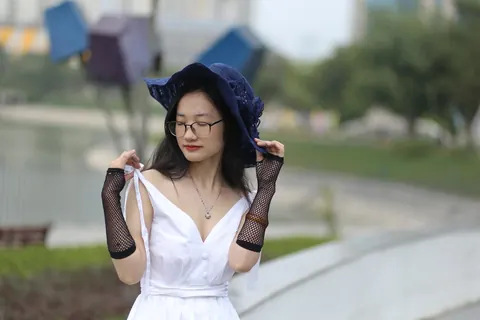 Asian Woman in Glasses and a Skirt Poses Outdoors – photo 2 of 21