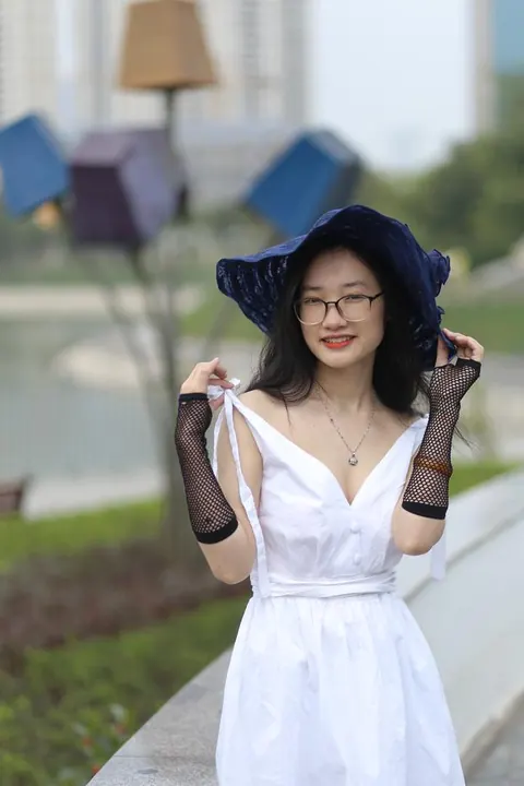 Asian Woman in Glasses and a Skirt Poses Outdoors – photo 20 of 21