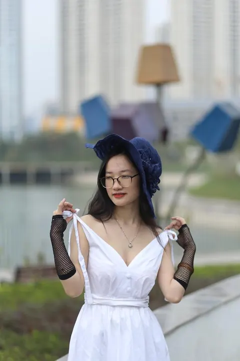 Asian Woman in Glasses and a Skirt Poses Outdoors – photo 4 of 21