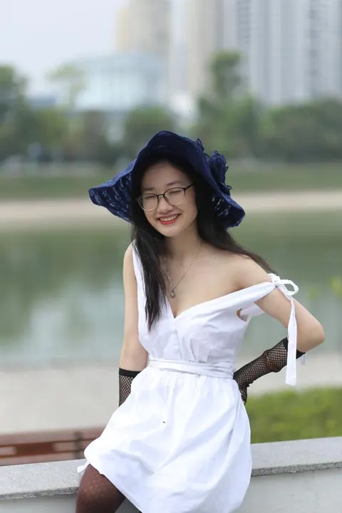 Asian Woman in Glasses and a Skirt Poses Outdoors – photo 18 of 21