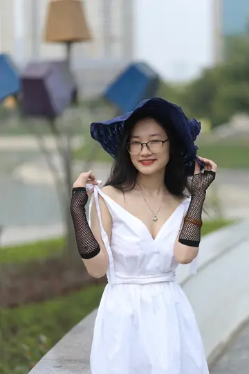 Asian Woman in Glasses and a Skirt Poses Outdoors