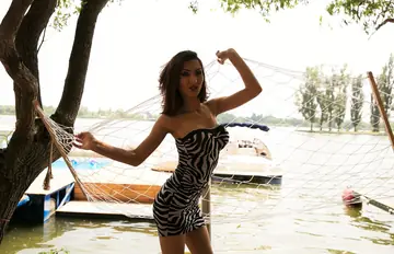 Brunette Poses in a Dress and Heels Showing Her Legs
