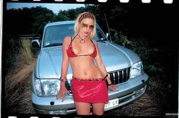Blonde MILF in a Bikini and Latex Takes Two Men Outdoors