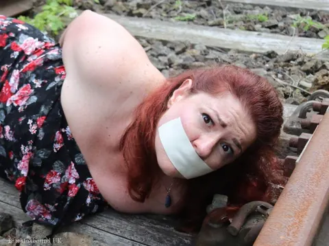 Redhead Bound and Gagged in a Skirt Outdoors – photo 11 of 16