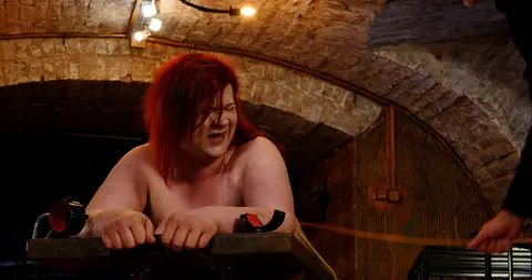 Redhead MILF Bound to Table Takes Hard Caning on Her Ass – photo 20 of 21
