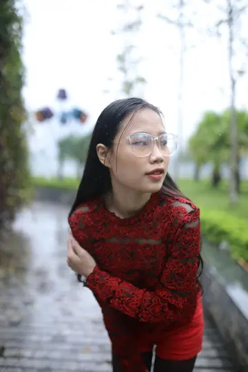 Asian Brunette Poses in Glasses Outdoors in a Public Place