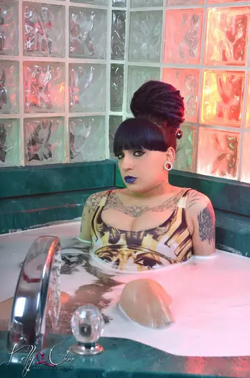Tattooed Trans Woman Oils Her Body in a Bikini