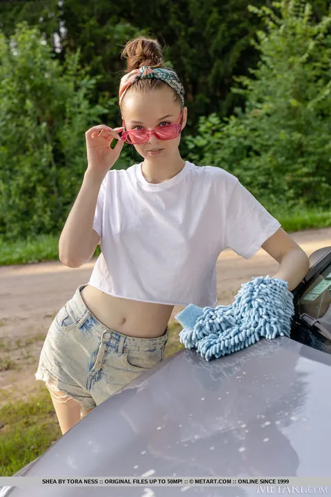 Brunette in Glasses and Shorts Strips Naked by a Car – photo 2 of 18