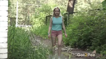 Blonde Squats and Pees on Concrete by Barred Door Outdoors