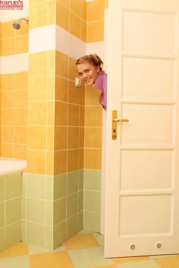Short-Haired Woman in Pigtails Spreads Her Shaved Pussy in the Bathroom
