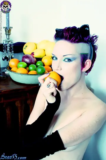 Tattooed Short-Haired Brunette Bites Citrus Fruit Nude