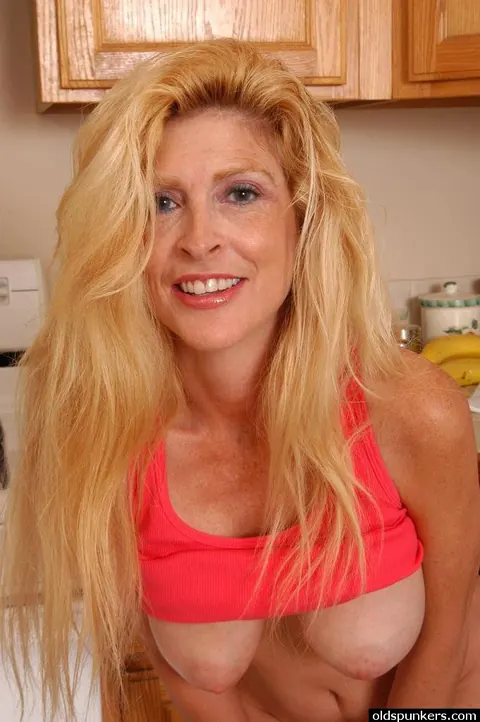 Sugar Kane: Mature Blonde Flashes Her Big Enhanced Tits and Spreads in the Kitchen – photo 9 of 16