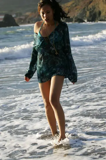 Woman in a Bikini Walks on a Sandy Beach