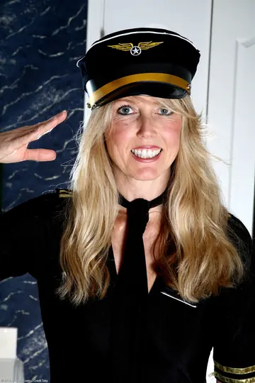 Blonde MILF in a Stewardess Uniform Spreads Her Trimmed Pussy