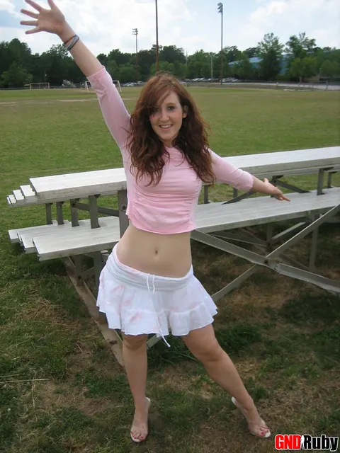 Redhead Flashes Panties in a Skirt and High Heels on Bleachers – photo 10 of 12
